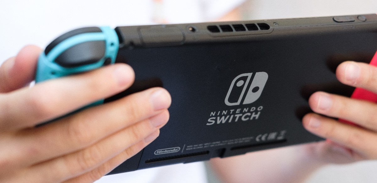 Person hält eine Nintendo Switch in der Hand.