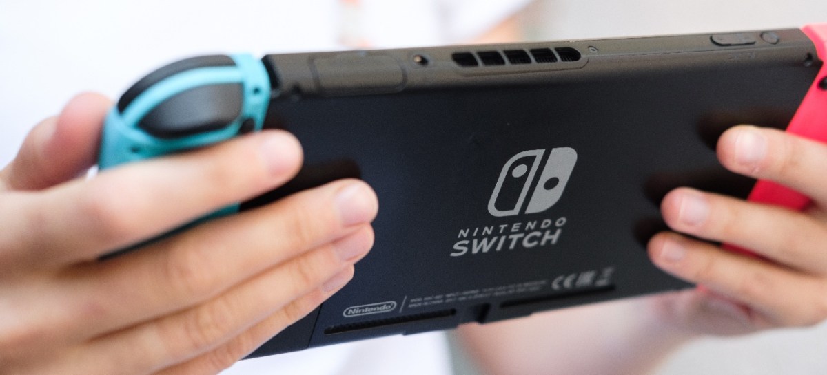 Person hält eine Nintendo Switch in der Hand.