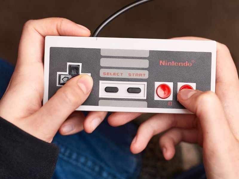 Person hält einen NES-Controller in der Hand.