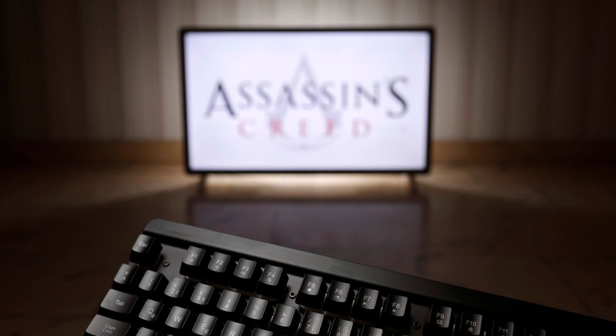 Bildschirm mit Assassin's Creed-Logo und Tastatur im Vordergrund